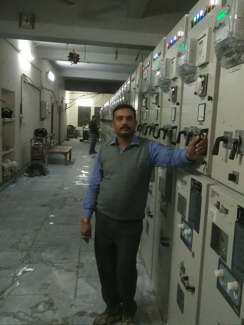 An engineer at a switchgear line-up in a substation control room