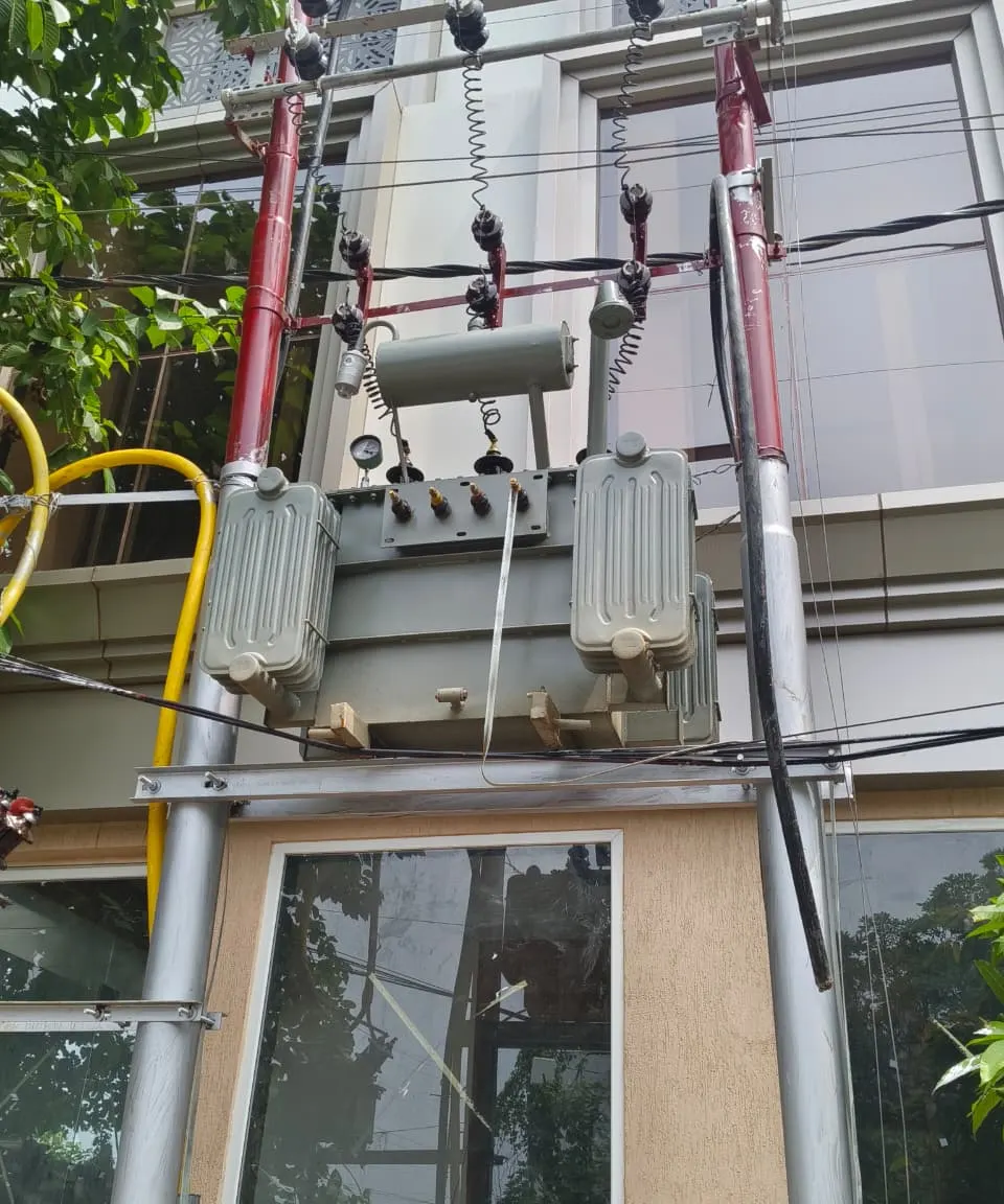 Transformer mounted on a double-pole structure, with its bushings and radiators in view